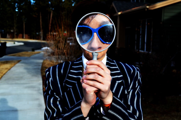 person using magnifying glass 